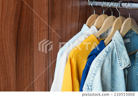 Clothing hanging on a clothing rack, brown home closet, copy space 110553008