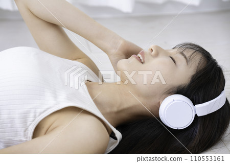 A woman lying on the floor and soaking in music A woman lying on the floor and soaking in music 110553161