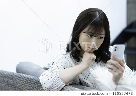 中年婦女在客廳的沙發上使用智慧型手機 110553478
