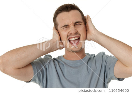 caucasian man in t-shirt covers ears with hands on white background caucasian man in t-shirt covers ears with hands on white background 110554600