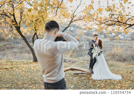 male wedding photographer taking pictures of the bride and groom male wedding photographer taking pictures of the bride and groom 110554734