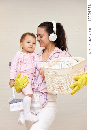 happy mother housewife is holding cute baby girl and basket with laundry , Happy family 110554758