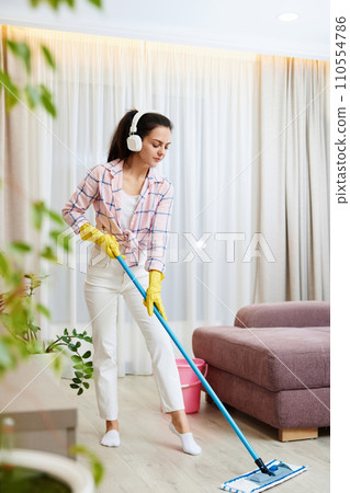 Happy woman singing and washing floor at living room, house chores. Happy woman singing and washing floor at living room, house chores. 110554786