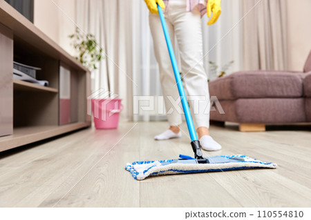 young woman cleaning and mopping floor at living room, daily housekeeping , close-up 110554810