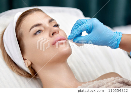 woman receives cosmetic injection in lips. Woman in beauty salon. woman receives cosmetic injection in lips. Woman in beauty salon. 110554822