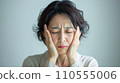 Middle-aged woman grimacing due to headache 1 110555006