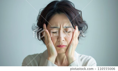 Middle-aged woman grimacing due to headache 1 110555006