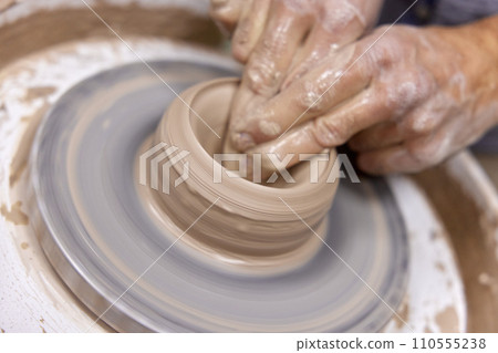 male hands making ceramic cup on pottery wheel, Close-up male hands making ceramic cup on pottery wheel, Close-up 110555238