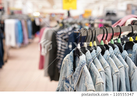Women's clothes Jean jackets on hangers in a retail shop. Fashion and shopping concept 110555347
