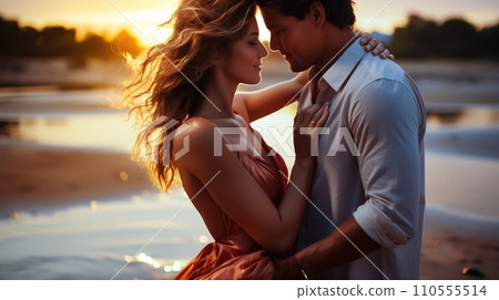 Ocean Love Affair: Young Couple in Beautiful Outfits Spinning and Hugging at Sunset 110555514