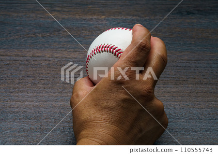 Man's hand holding a hardball baseball ball Man's hand holding a hardball baseball ball 110555743