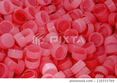 The pile of red plastic caps of drinking water bottles. 110555769