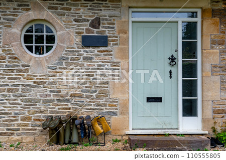 Entrance Of A Cottage With Rubber Boots Of Different Size Beneath The Door In England Entrance Of A Cottage With Rubber Boots Of Different Size Beneath The Door In England 110555805
