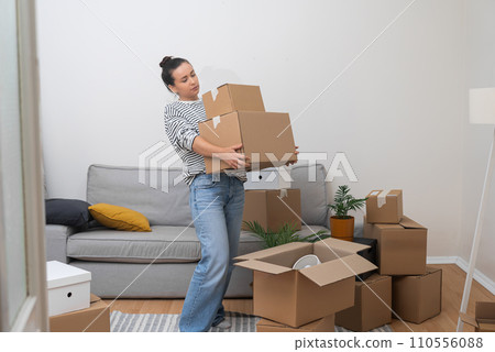 Female carries cardboard boxes with supplies for moving to new accommodation change of scenery and packing items to order delivery to another address Female carries cardboard boxes with supplies for moving to new accommodation change of scenery and packing items to order delivery to another address 110556088