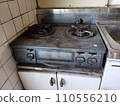 Dirty kitchen with gas stove, oil stains and yellowing on the walls, rusty and dusty stove that has not been cleaned. 110556210