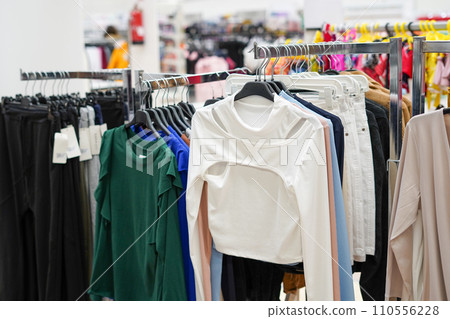 Colorful women's clothes on hangers in a retail shop. Fashion and shopping concept 110556228