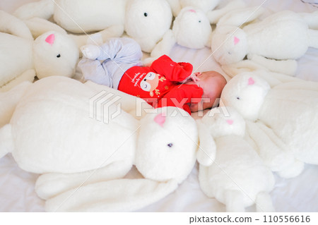 Sleeping infant baby boy with many dolls rabbit on white blanket newborn concept 110556616