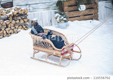 A father takes his son for a ride in the woods in winter A father takes his son for a ride in the woods in winter 110556702