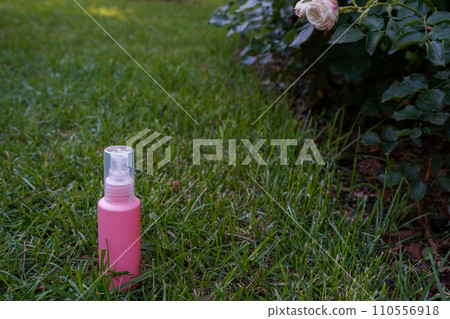 Pink cosmetic bottle on nature background staying in the garden 110556918