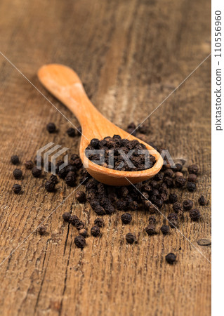 black pepper on wooden spoon 110556960