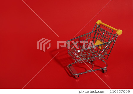 Shopping trolley on red background with copy space 110557009