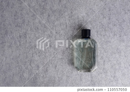 Men perfume bottle on gray textile background, copy space Men perfume bottle on gray textile background, copy space 110557050