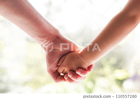 Father holds daughter by the hand close-up. light sunny background, Support and family love 110557280