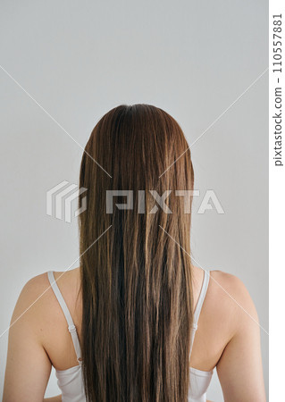 從後面看,一名 30 多歲的女性,穿著背心 從後面看,一名 30 多歲的女性,穿著背心 110557881