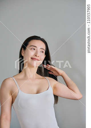 A woman in her 30s with long hair combing her hair 110557905