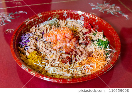 Serving of yusheng or yee sang with raw salmon during Chinese New Year believed to bring good luck and prosperity Serving of yusheng or yee sang with raw salmon during Chinese New Year believed to bring good luck and prosperity 110559008