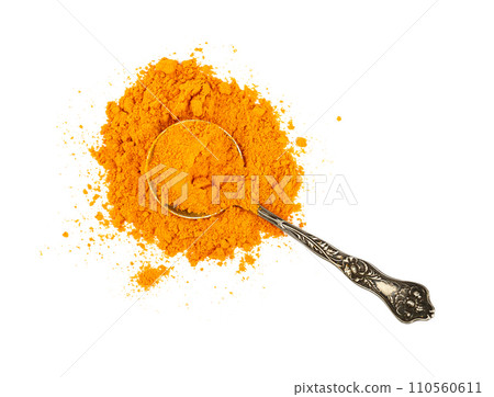 Metal spoon full of yellow turmeric powder 110560611