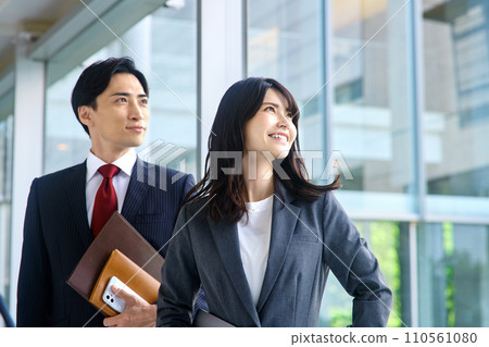 A businessman working in an office and a business woman 110561080