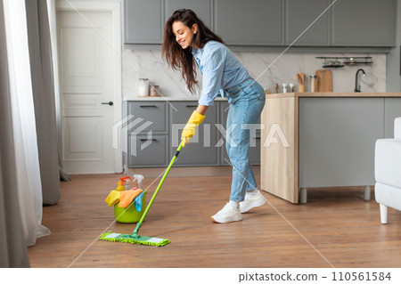 Woman in blue shirt cleaning floor with mop and bucket 110561584