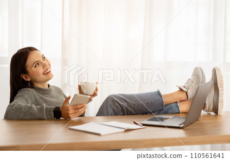Joyful young woman employee relaxing at workplace Joyful young woman employee relaxing at workplace 110561641