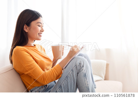 Beautiful young asian woman makes plan for today Beautiful young asian woman makes plan for today 110561878