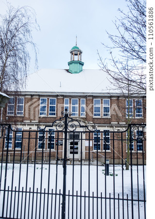 Historic brick school building covered in snow, cityscape on the outskirts of London Historic brick school building covered in snow, cityscape on the outskirts of London 110561886