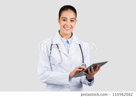 Engaged european doctor in a lab coat and stethoscope using a digital tablet Engaged european doctor in a lab coat and stethoscope using a digital tablet 110562082