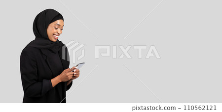 Smiling African American businesswoman in a hijab engaged in a pleasant conversation on her mobile phone 110562121