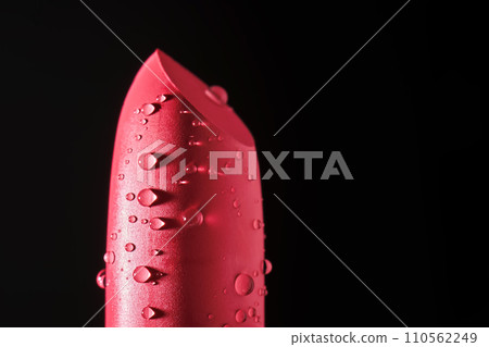 Red lipstick with water drops on a dark background. 110562249