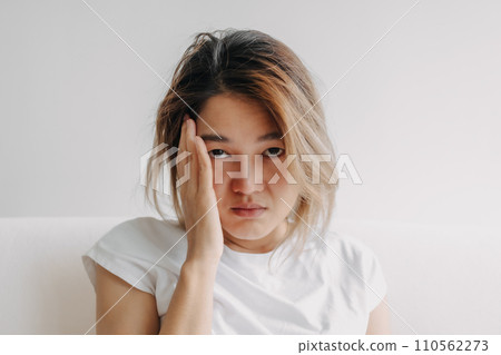 Close up headshot of headache hangover woman with hand covering her head. 110562273