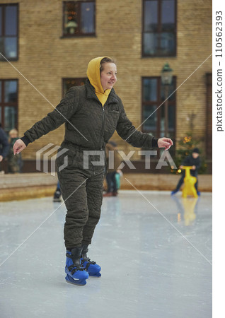 Woman on an ice skating rink in Denmark in the evening Woman on an ice skating rink in Denmark in the evening 110562393