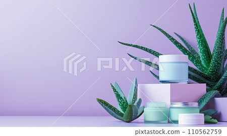 Arrangement of aloe skincare products, delicate containers set with aloe vera leaves on a pastel lavender background 110562759