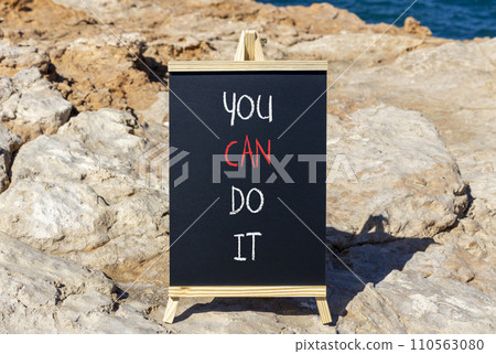 You can do it symbol. Concept word You can do it on beautiful black chalk blackboard. Beautiful red stone blue sea background. Business motivational you can do it concept. Copy space. You can do it symbol. Concept word You can do it on beautiful black chalk blackboard. Beautiful red stone blue sea background. Business motivational you can do it concept. Copy space. 110563080