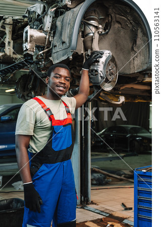 Portrait of young african man car service worker wearing uniform standing in garage 110563141