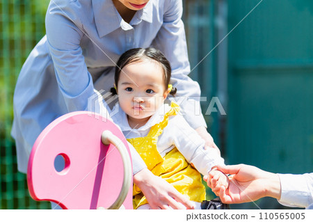 Family with kids, mom and cute girl playing in park 110565005
