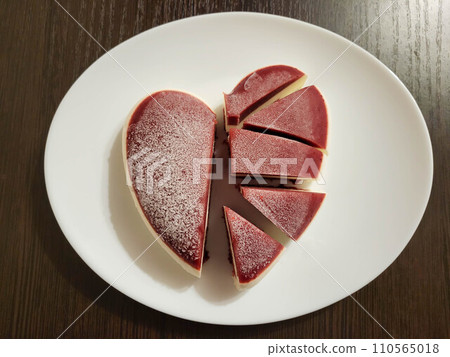 Mousse cut cake in the shape of a heart on a white plate. The concept of Valentine's Day, mother's day, birthday, celebration concept. 110565018