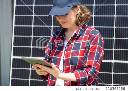 Woman with digital tablet next to solar power station Woman with digital tablet next to solar power station 110565266