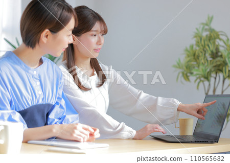 Two female designers having a meeting while looking at a color chart_2 Two female designers having a meeting while looking at a color chart_2 110565682