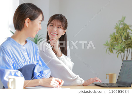 Two female designers having a meeting while looking at a color chart_4 110565684