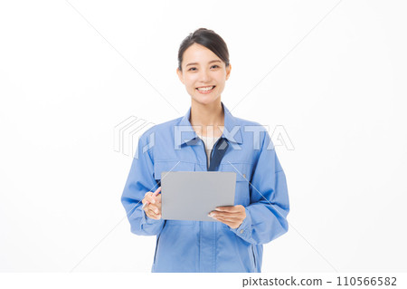 A woman wearing work clothes holding documents 110566582